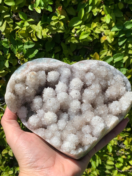 CRYSTAL STALATITE HEART WITH  SMALL BLACK POINTS OF  CALCADONY